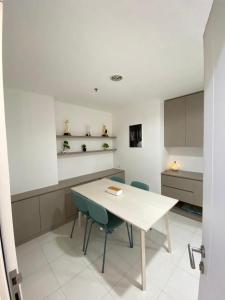 a kitchen with a white table and chairs at Win Sentul Tower Apartement in Citaringgul 1