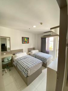 a hotel room with two beds and a sink at Win Sentul Tower Apartement in Citaringgul 1
