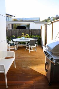 凯库拉Kaikoura Blue haven in the bay的带桌椅和烤架的露台