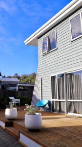 凯库拉Kaikoura Blue haven in the bay的一栋房子，木平台上放着两个花盆