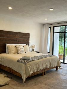 Un dormitorio con una cama grande con cabecero de madera. en Casa Madera 1C, en Zacatlán
