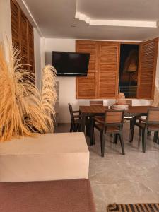 a dining room with a table and chairs and a tv at LA VICTORIA Casa tropical con piscina privada in Carmen de Apicalá