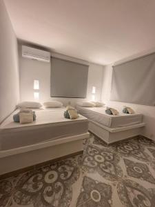 two beds in a room with two windows at LA VICTORIA Casa tropical con piscina privada in Carmen de Apicalá