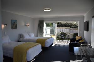 a hotel room with two beds and a balcony at Trailblazer Studios in Waihi
