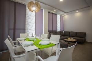 a dining room with a table and chairs and a couch at Bozikovic 365 in Podstrana