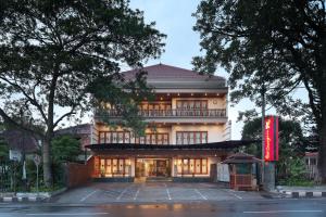 a building with a red sign in front of it at Kertanegara Premium Guest House in Malang