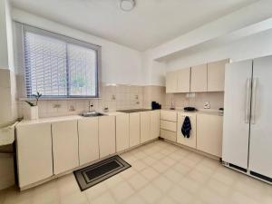 een grote keuken met witte kasten en een raam bij Apartamento frente a Bahía de Pampatar in Pampatar +16 foto's