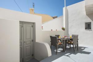 a patio with a table and chairs on a building at Villa Aegeon Grande in Megalochori