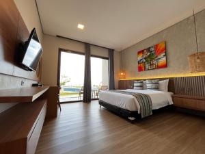 a bedroom with a bed and a flat screen tv at Tropical Beach Resort Sekongkang in Sekongkang Bawa