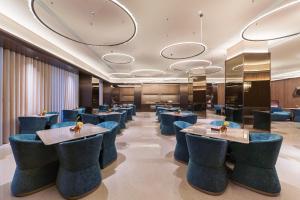 un ristorante con sedie e tavoli blu di 上海浦东机场祝桥桔子水晶酒店 a Shanghai