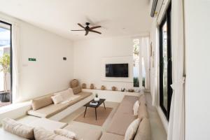 a living room with a couch and a ceiling fan at Villa Casa More by BaliSuperHost in Ungasan