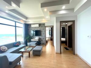 un salon avec un canapé bleu et une table dans l'établissement Blue Sea Hon Chong - Beachfront Apartment, à Nha Trang