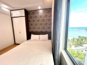 une chambre avec un lit et une fenêtre avec l'océan dans l'établissement Blue Sea Hon Chong - Beachfront Apartment, à Nha Trang