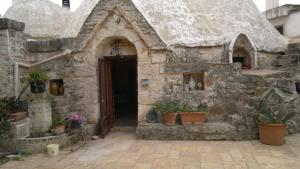 a small house with potted plants in front of it at Masseria Donna Licia in Pezze di Greco