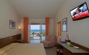 a hotel room with a bed and a flat screen tv at Hotel Montecarlo in Lido di Camaiore