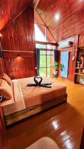 une chambre avec un grand lit avec un mur en bois dans l'établissement ในสวนรัตนมณีรีสอร์ท, à Ban Pak Khlong