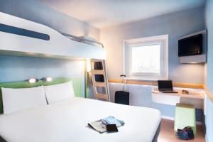 een slaapkamer met een bed en een stapelbed bij Ibis Budget Clermont Ferrand - Le Brezet - Aeroport in Clermont-Ferrand