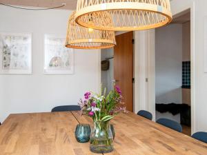 a dining room table with a vase of flowers at 9 person holiday home in Rømø in Vesterhede +23 photos