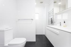 BundeenaにあるDiscover Lambeth Walk Beach Homeのトイレと洗面台を備えた白いバスルーム +45枚の写真