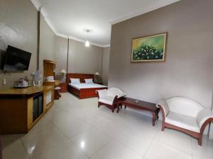 a living room with a couch and a tv at Sapadia Hotel Parapat in Parapat