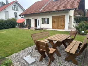 a wooden picnic table and chairs in a yard at Fewo Susi Allgäu in Buchloe