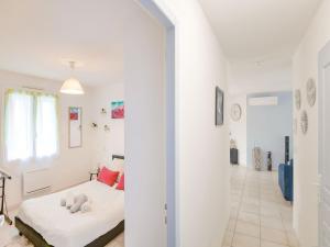 ein weißes Zimmer mit einem Bett und einem Flur in der Unterkunft Zen room in a private home with a swimming pool in Saint-Médard-de-Guizières