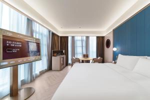 una camera d'albergo con un letto e una TV a schermo piatto di 上海浦东机场祝桥桔子水晶酒店 a Shanghai