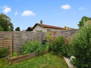 einen Zaun in einem Garten mit einem Haus dahinter in der Unterkunft Zen room in a private home with a swimming pool in Saint-Médard-de-Guizières