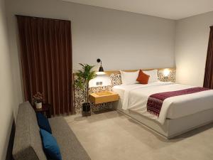 una camera da letto con un grande letto bianco e un divano di Padinis Villa & Coffee a Ketewel Altre 71 foto