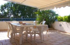 a white table and chairs on a patio at Lu Sule in Torre Vado