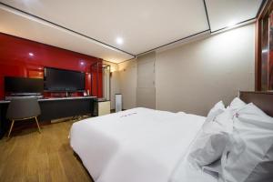 a bedroom with a bed and a desk and a television at Motel Flower in Seoul