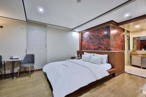 a bedroom with a large white bed and a desk at Motel Flower in Seoul
