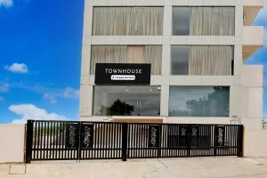 a tall building with a sign for a townhouse at Townhouse Maralkunte near Shree Kateramma Temple in Bayappanhalli