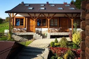 a house with a porch with a roof at Cztery Pliszki in Gródek Nad Dunajcem