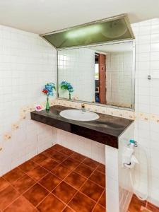 ein Badezimmer mit Waschbecken und Spiegel in der Unterkunft OYO 441 Grand Thara Hotel in Surat Thani + 146 Fotos