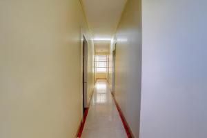 a hallway with white walls and a long corridor at Hotel O Sainagar Shirdi Railway Junction Formerly Sai Vyankatesh Residency in Shirdi