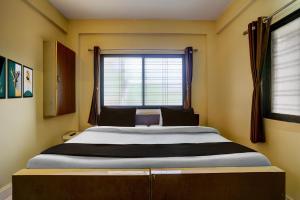 a large bed in a room with a window at Hotel O Sainagar Shirdi Railway Junction Formerly Sai Vyankatesh Residency in Shirdi +21 photos