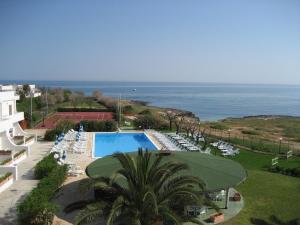 a view of a resort with a swimming pool and the ocean at Residence Club Barbara in Ostuni