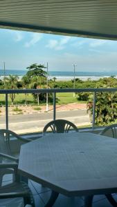 a table and chairs with a view of the beach at Indaia Apartamento de Frente ao Mar in Bertioga