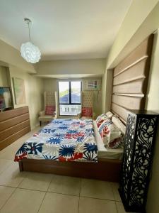 a bedroom with a large bed and a window at Relaxing Escape lovely STUDIO unit with a pool in Tagaytay