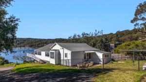 a white house on the side of a body of water at 'Torcello - Waterfront on the Bay' by HolidayCo in Hardys Bay