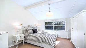 a bedroom with a bed and a window at 'Torcello - Waterfront on the Bay' by HolidayCo in Hardys Bay
