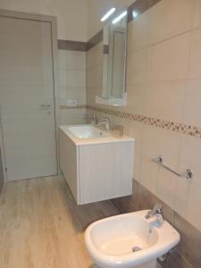 La salle de bains blanche est pourvue d'un lavabo et d'une douche. dans l'établissement Apartment I Mastrazzi, à Riposto