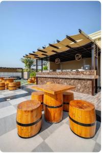 a table and four wooden stools in front of a bar at Emora 1 BR Apartment in Dubai