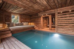 a large swimming pool in a wooden house with a bench at Chalet 1864 in Le Grand-Bornand