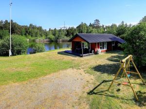 a small red cabin on the side of a lake at 4 person holiday home in Læsø in Læsø