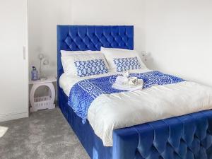 ein blaues Bett mit blauem Kopfteil in einem Schlafzimmer in der Unterkunft Amayrah Cottage in Inverness