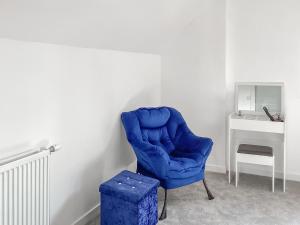 einem blauen Stuhl in einem Zimmer mit einem Schreibtisch in der Unterkunft Amayrah Cottage in Inverness
