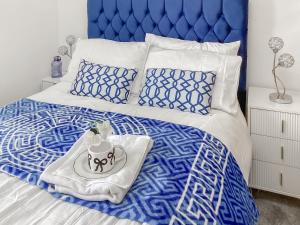 ein blau-weißes Bett mit einem Tablett mit einem Kuchen darauf in der Unterkunft Amayrah Cottage in Inverness + 7 Fotos