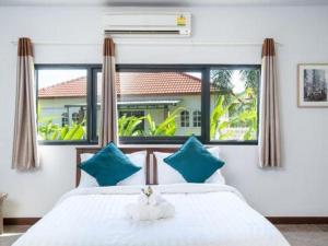 une chambre avec un lit avec un animal en peluche dessus dans l'établissement Dudnapa Pool Villa Hua Hin, à Hua Hin 205 autres photos